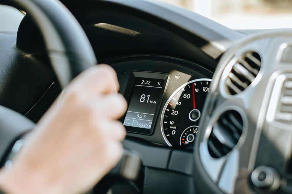 Hands on the wheel of a car on a sunny day