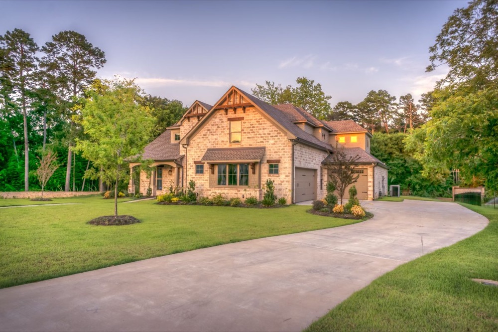 Large estate home with long driveway at dusk