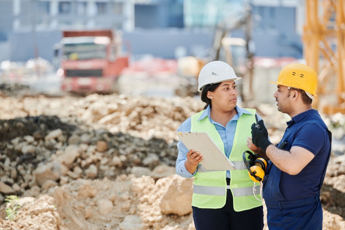 Two workers in hard hats at a job site